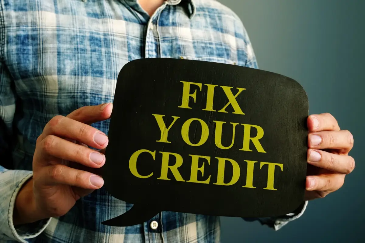 Man holding sign that says "fix your credit" representing the factors that affect your credit score