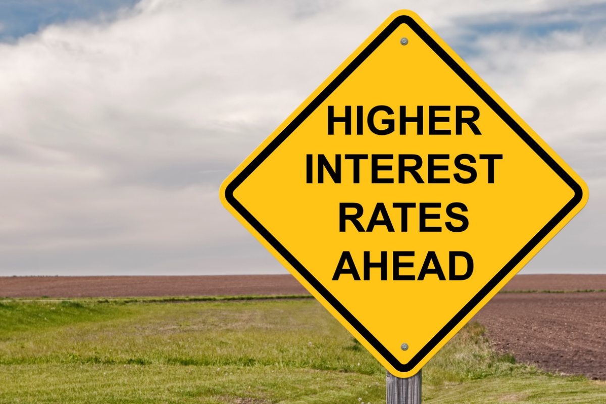 Yellow traffic sign announcing "higher interest rates ahead," representing the impact of higher interest rates on unsecured loans.